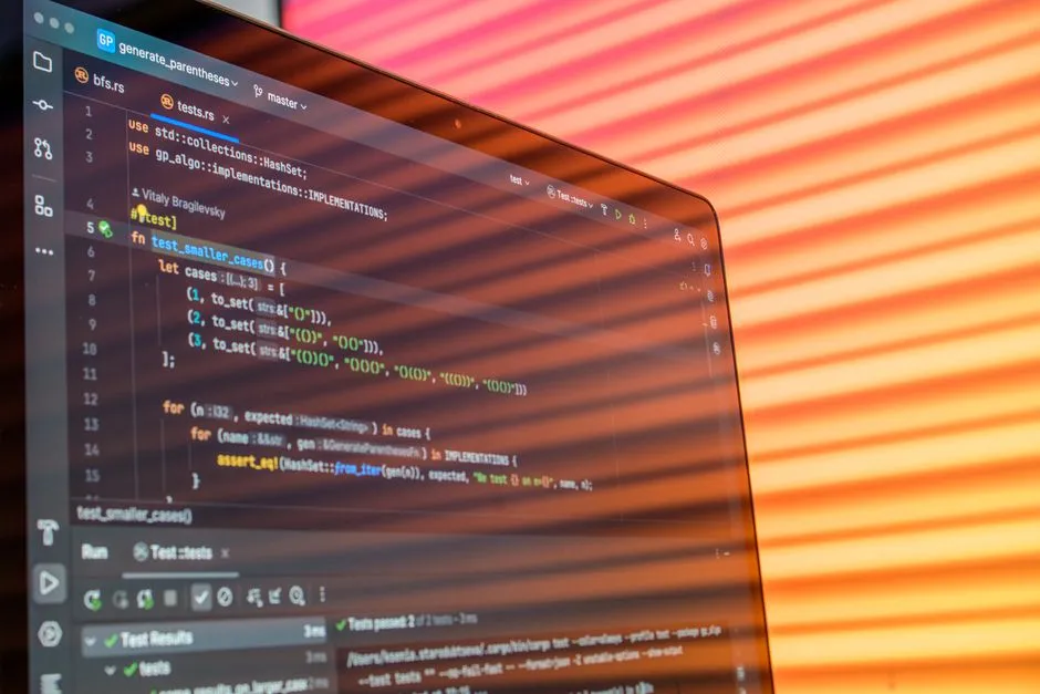 Source code open in an editor on a laptop screen lit by orange light