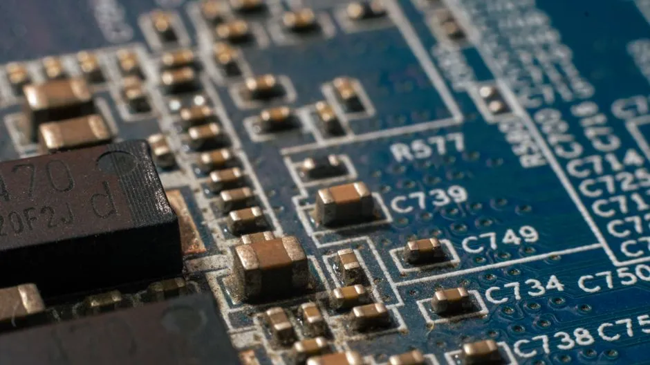 Close-up of a printed circuit board showing surface-mounted components and their designators, illustrating a report on Nvidia licensing Poolside's model-building system.