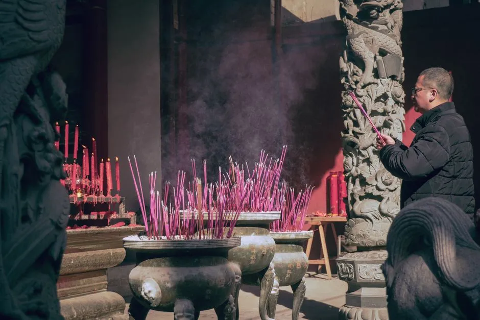 Incense sticks smouldering in bronze burners at a Chinese temple