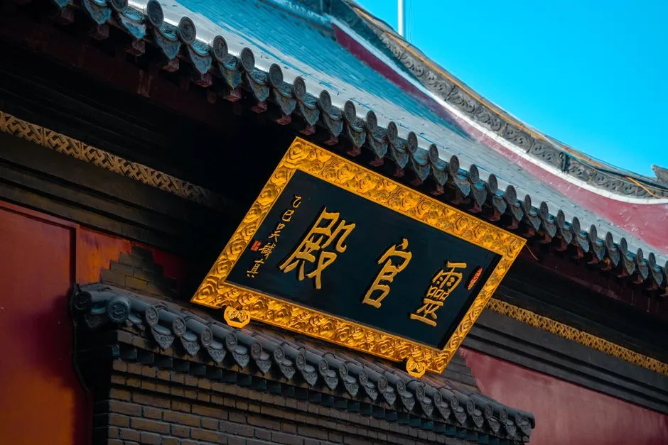 A gilded Chinese signboard mounted beneath a temple eave