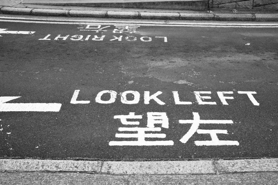A Hong Kong road marking reading LOOK LEFT in English above 望左 in Chinese