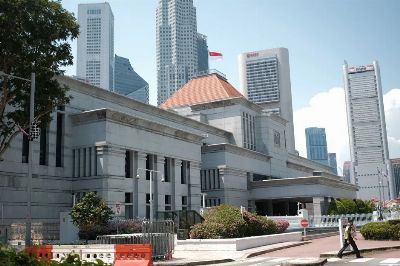 A view of Singapore's urban landscape featuring iconic skyscrapers and a prominent building under a clear sky.