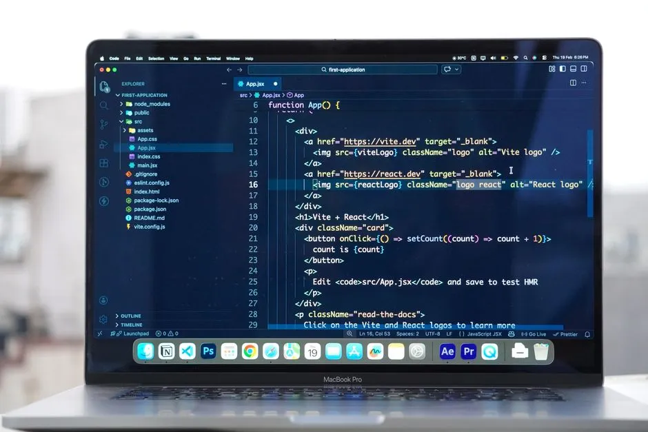 A laptop screen showing a code editor with a project file tree on the left and a JavaScript component open, photographed against a blurred window