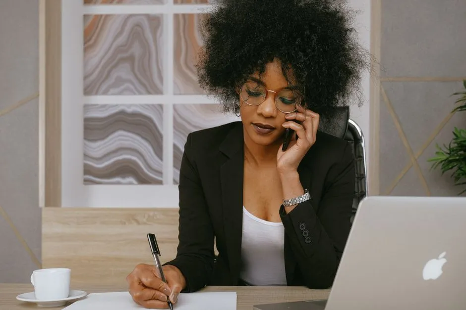 A salesperson taking a call at a desk with a laptop and notes, the work the 37 prebuilt skills are aimed at