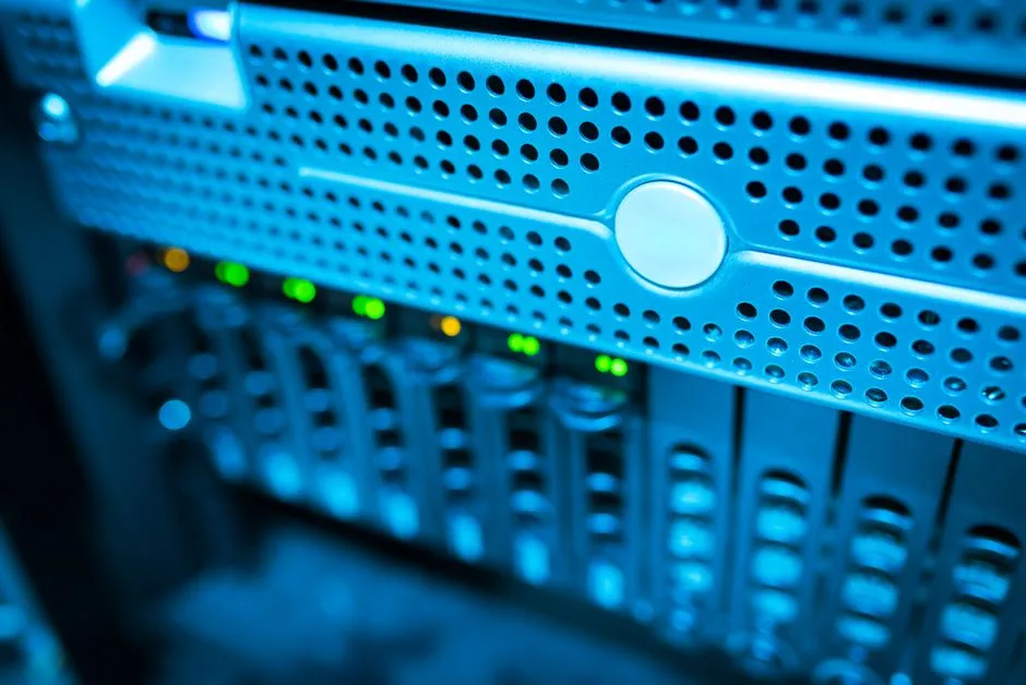 Focused view of a modern data server rack with blinking lights in a blue-lit environment.