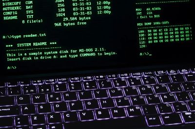A classic MS-DOS terminal screen displayed on a laptop keyboard with vivid illumination.
