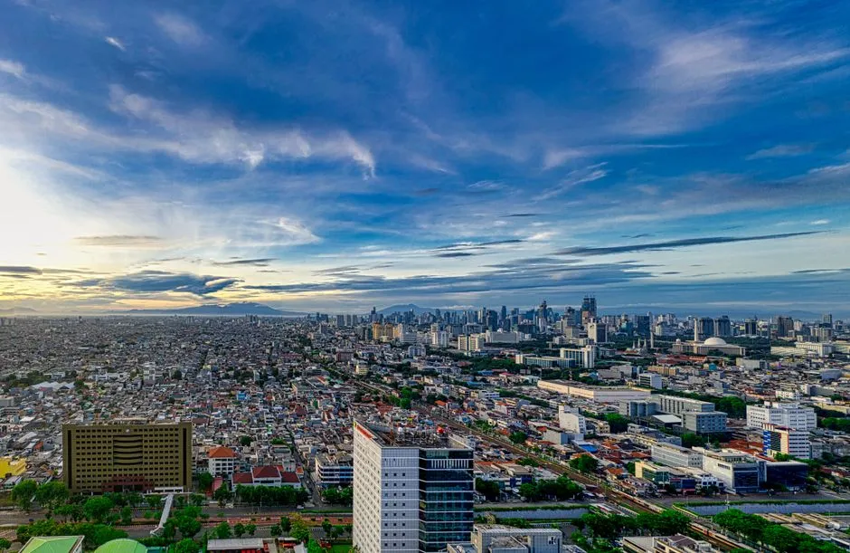 Stunning aerial view of Jakarta's cityscape at dusk, capturing its modern skyline and urban sprawl.