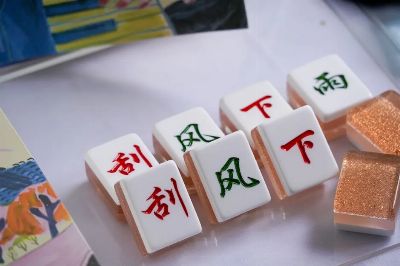 Close-up image of Mahjong tiles featuring Chinese characters on a tabletop.