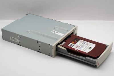 Vintage computer backup tape drive with open tray, showcasing retro technology.