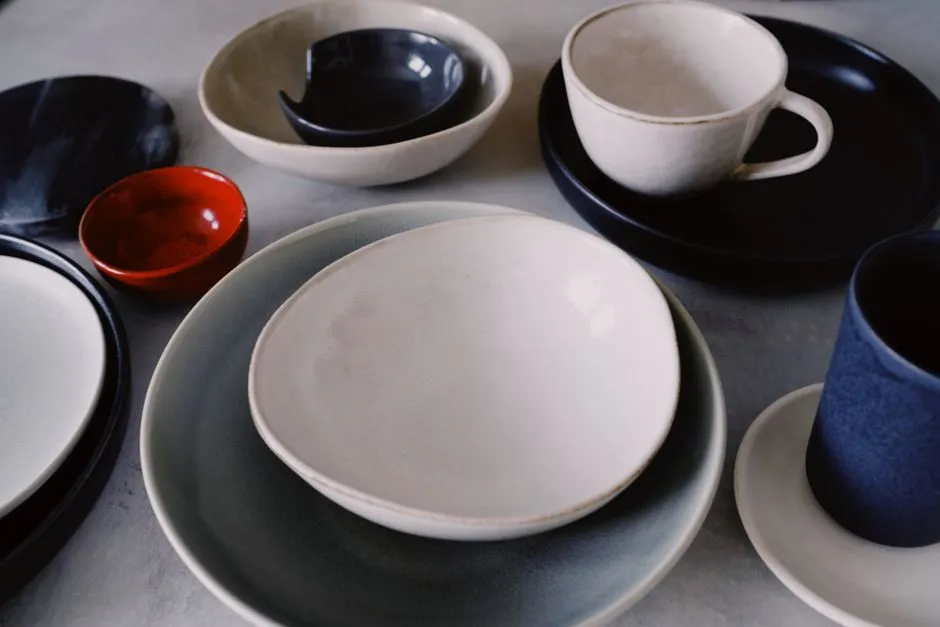 Empty cups, bowls and plates of different sizes laid out on a grey table