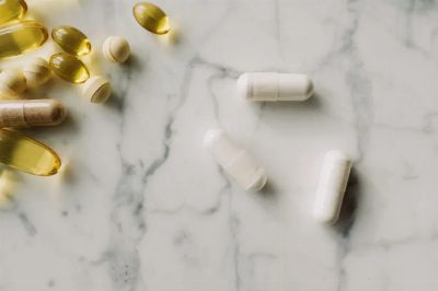 Close-up of various pills and capsules on a marble surface, ideal for healthcare themes.