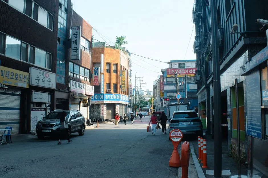 A commercial street in South Korea lined with Hangul shop signage, illustrating a report on the Korean AI Basic Act seven months after it took effect.