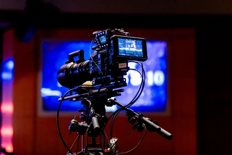 A professional video camera on a tripod facing a lit studio set, illustrating a report on a change to how a video platform counts views.