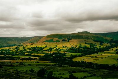 Scenic view of the lush rolling hills and patchwork fields in Peak District, England.