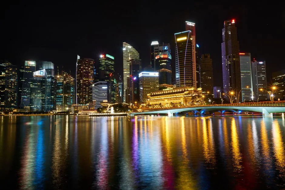 Singapore's central business district lit at night across Marina Bay, illustrating a report on the financial-sector taskforce formed against AI-driven cyber threats.