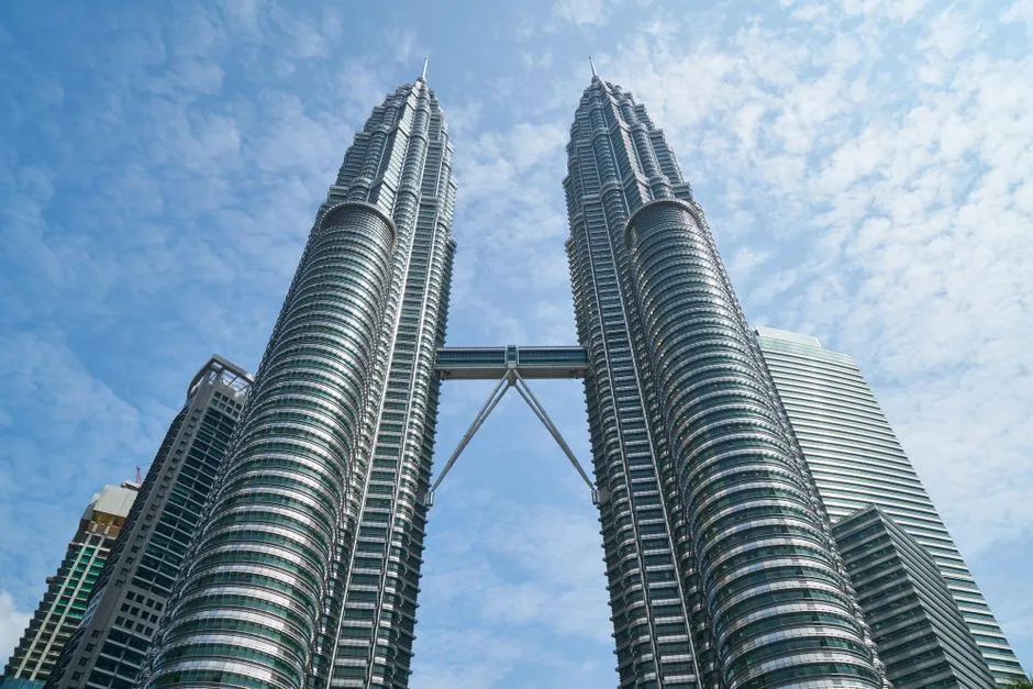 The Petronas Twin Towers in Kuala Lumpur seen from below against a blue sky