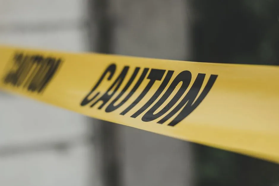 Close-up image of yellow caution tape with blurred background, emphasizing warning and safety.