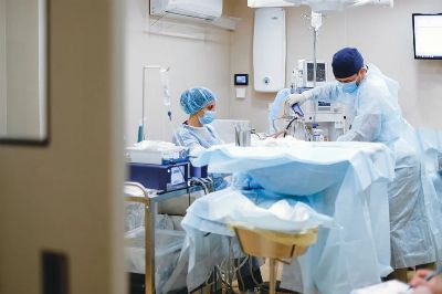 Surgeons and medical staff in a sterile operating room conducting a surgical procedure.