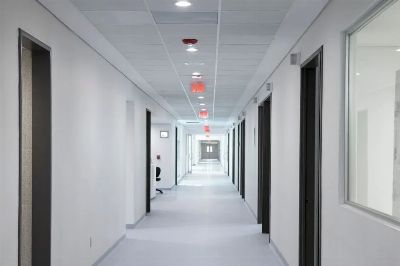 White-walled hospital corridor with modern design and bright overhead lighting.