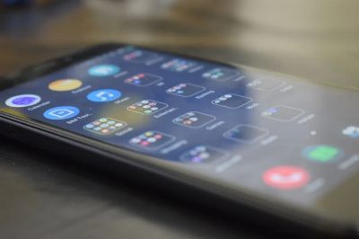 Close-up shot of a smartphone screen showing various app icons, indicating digital technology use.