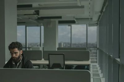 Man working in a modern open-plan office with a city view.
