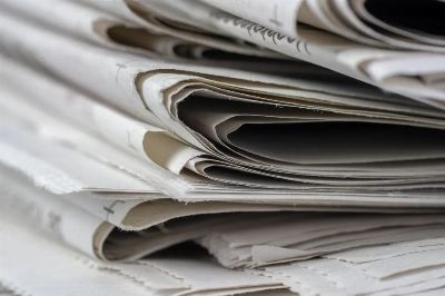 A detailed close-up view of stacked newspapers, highlighting textures and layers.