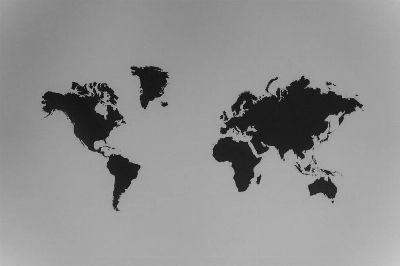 A simple black and white silhouette of a world map emphasizing continents against a stark background.