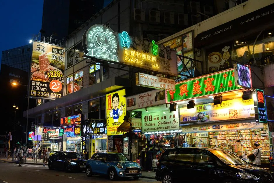 Shop signs in traditional Chinese characters lit up along a Hong Kong street at night