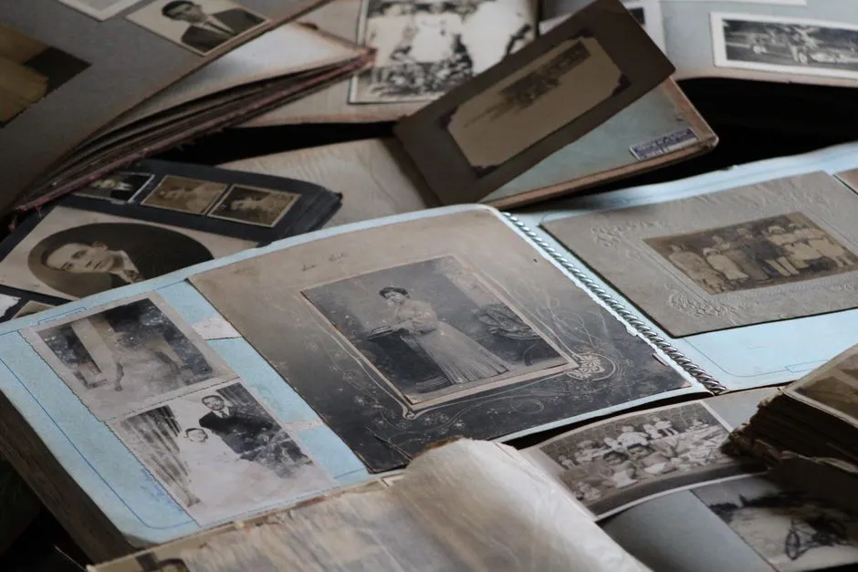 Old black-and-white family photographs spread across the open pages of worn albums