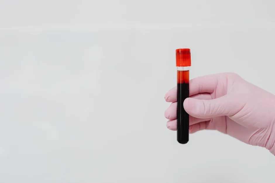 Gloved hand holding a filled blood collection tube, illustrating the kind of lab result this model change affects.