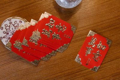 A collection of traditional red envelopes for Chinese New Year on a wooden surface.