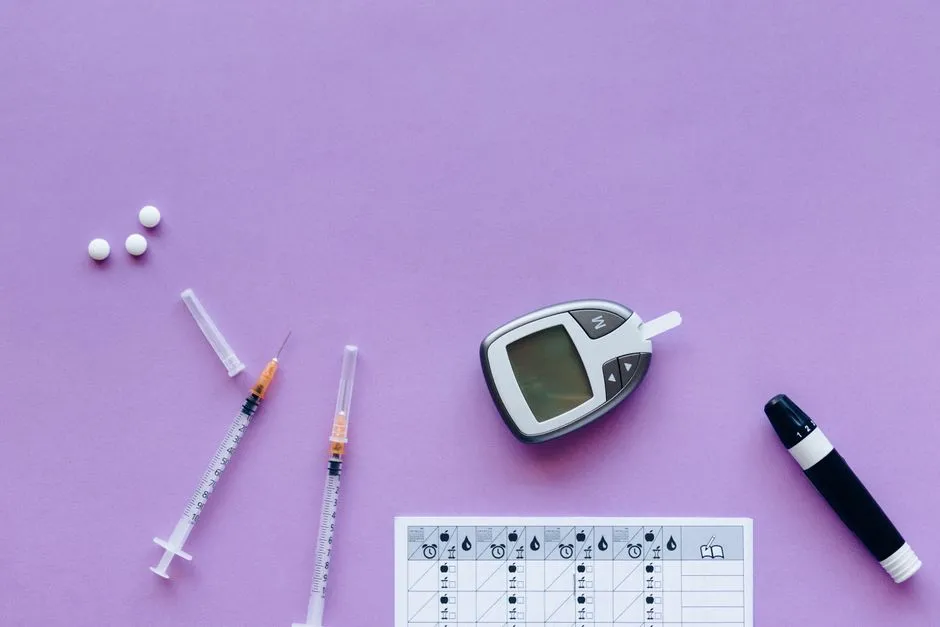 Syringes, a blood glucose meter and a lancing device on a purple surface