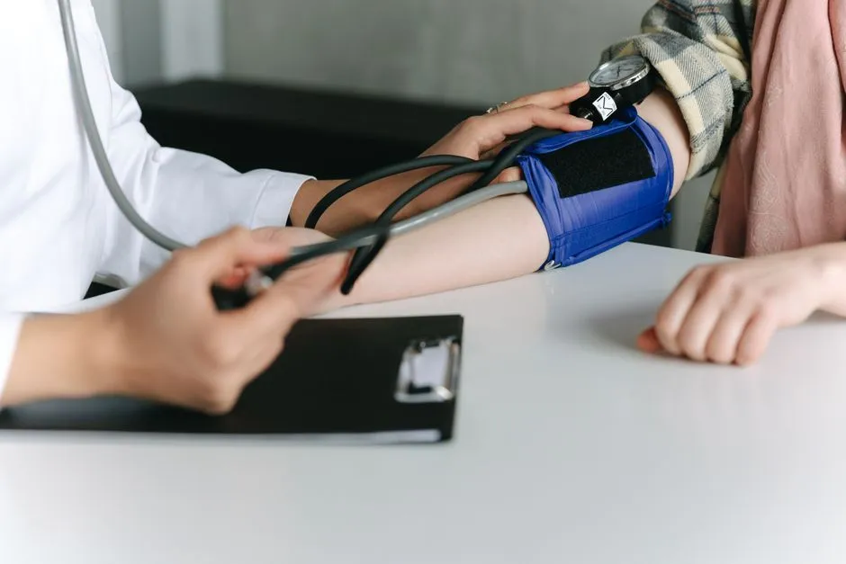 A clinician taking a blood pressure reading with a cuff on a patient's arm
