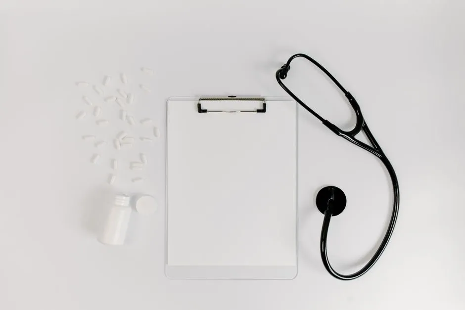 A blank clipboard beside a stethoscope on a white surface