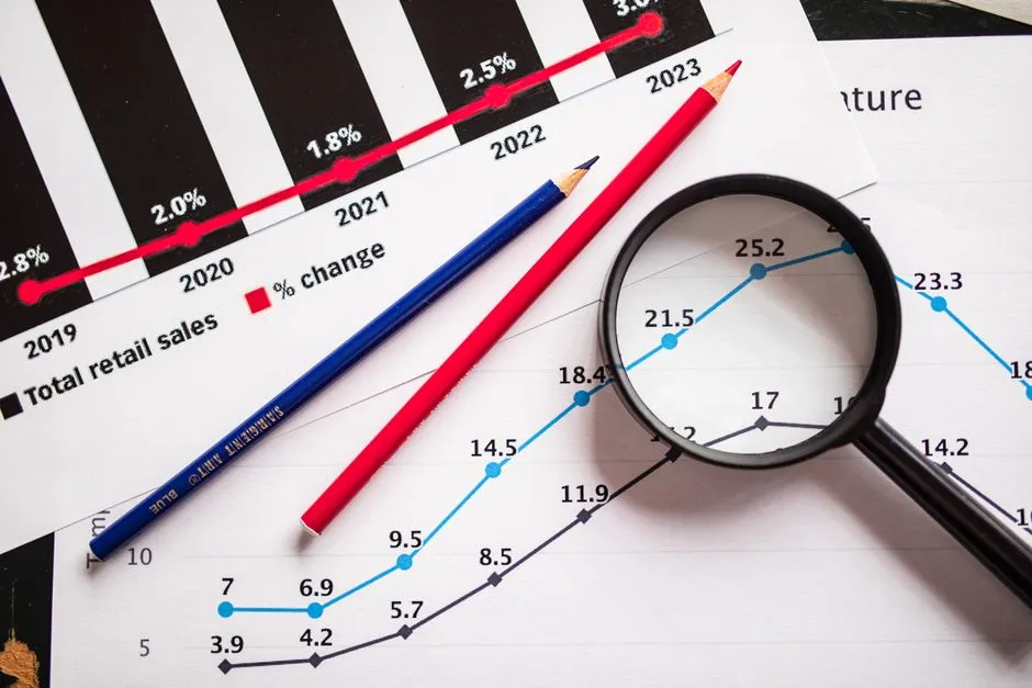 Printed financial charts examined through a magnifying glass, a generic illustration for a report on the difference between an annualised run rate and revenue recognised in a period.