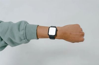 A close-up view of a smartwatch with blank screen on an adult's wrist, ideal for mockup designs.