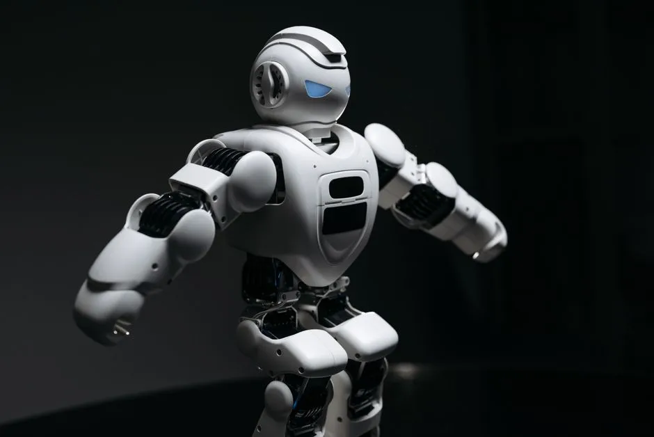 A small white humanoid robot standing with arms raised against a dark background, illustrating a report on the first humanoid robot maker to list in mainland China.
