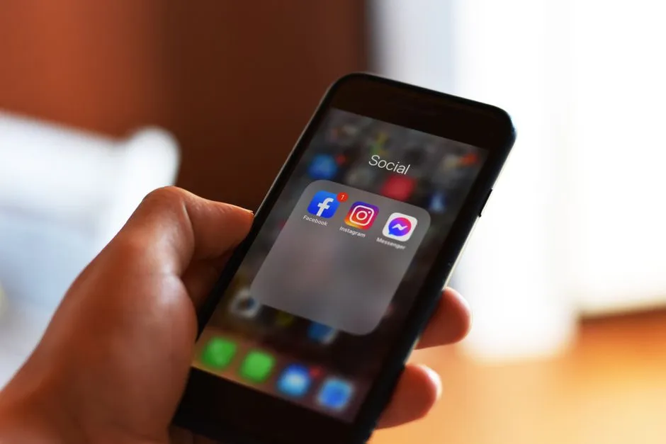 Hands holding a smartphone, its screen lit, in close view.