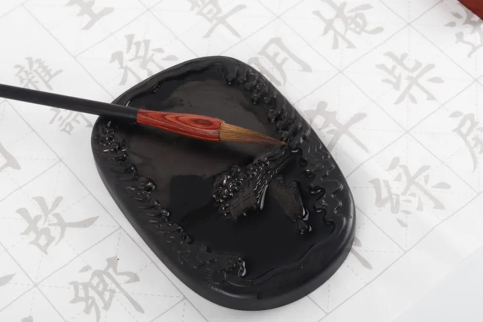 A calligraphy brush resting on an inkstone over a practice sheet of Tang verse characters