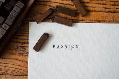 Vintage rubber stamps spelling 'passion' on paper, styled on wooden surface.