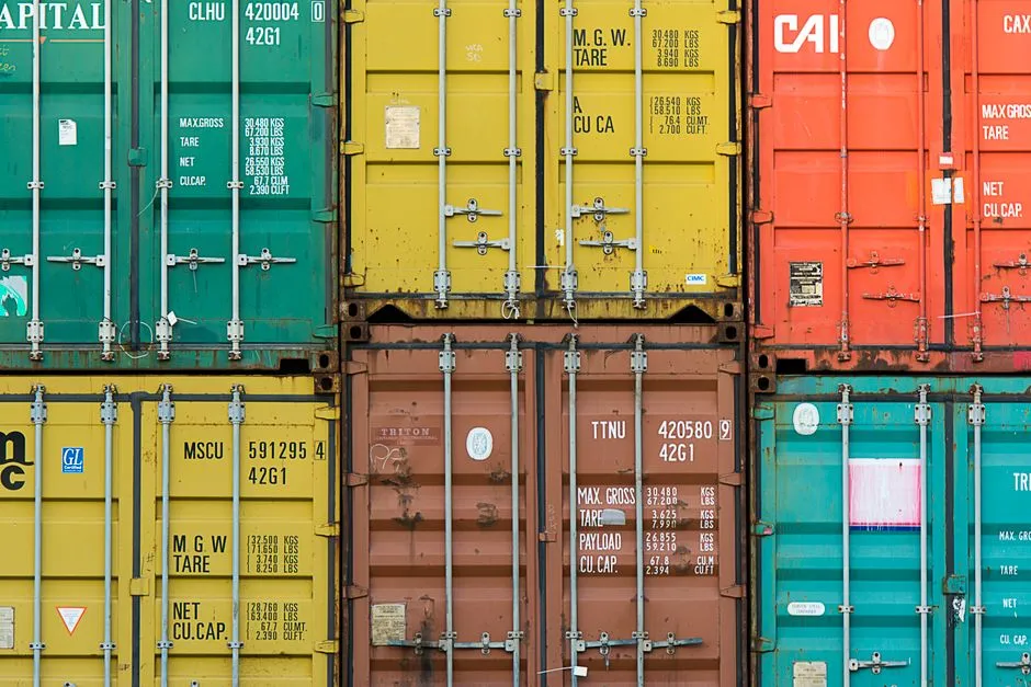 Shipping containers stacked in a grid, viewed head-on at their doors
