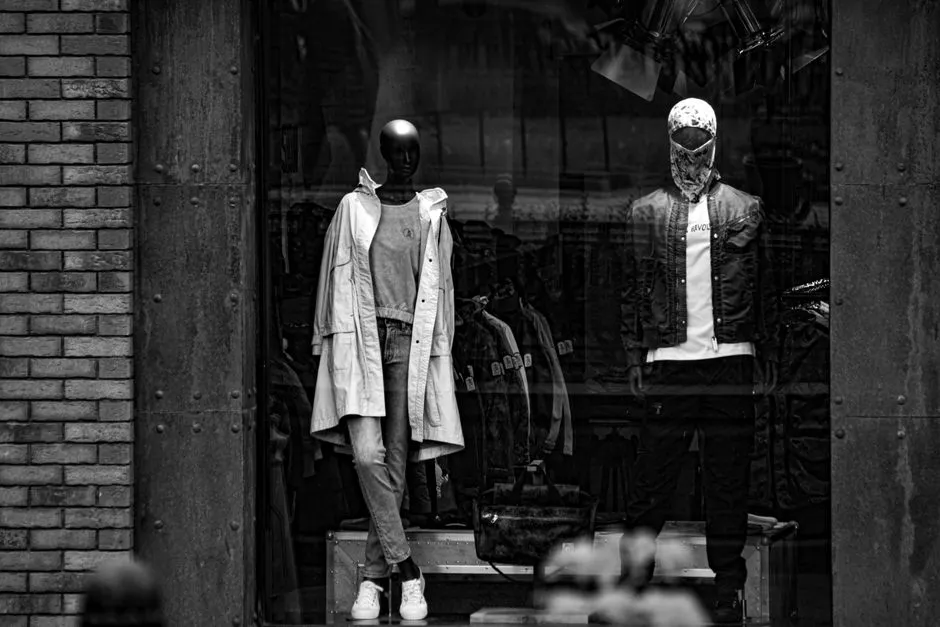 Featureless mannequins standing in a shop window, photographed in black and white
