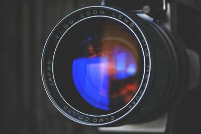 Detailed close-up of an Elmo zoom camera lens capturing vivid reflections. Perfect for photography enthusiasts.