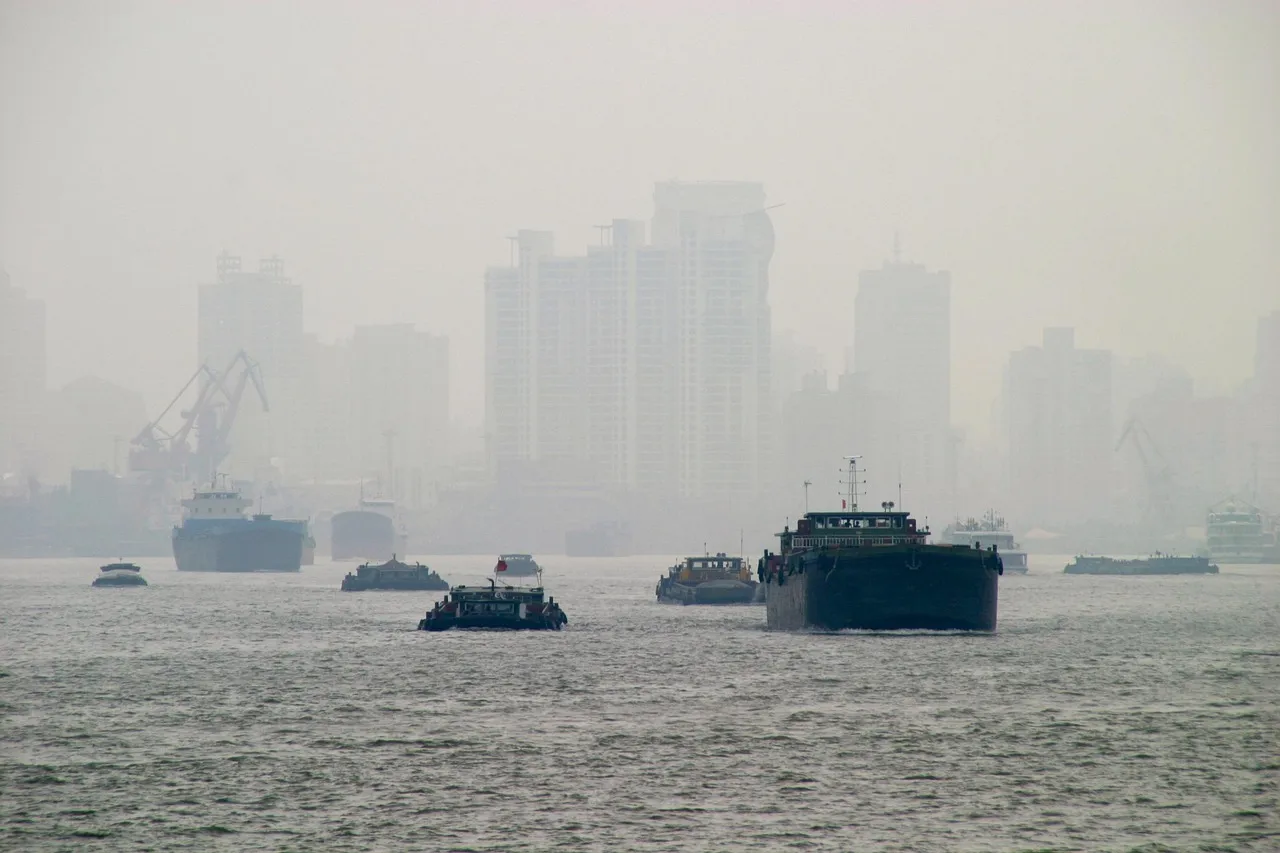 A city skyline obscured by grey haze over the water