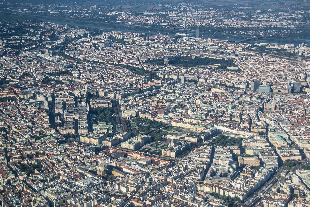 High-altitude aerial view of a dense European city, streets and rooftops visible from above