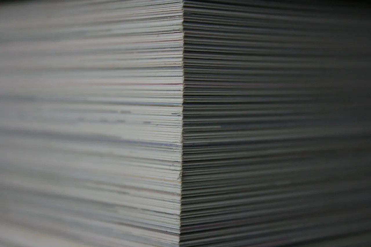 The edge of a tall stack of printed paper filling the frame.