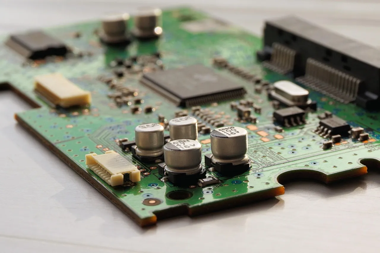A green circuit board fitted with chips and components
