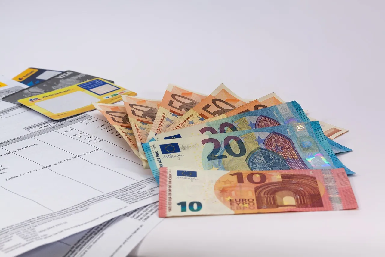 Euro banknotes lying on printed bank statements
