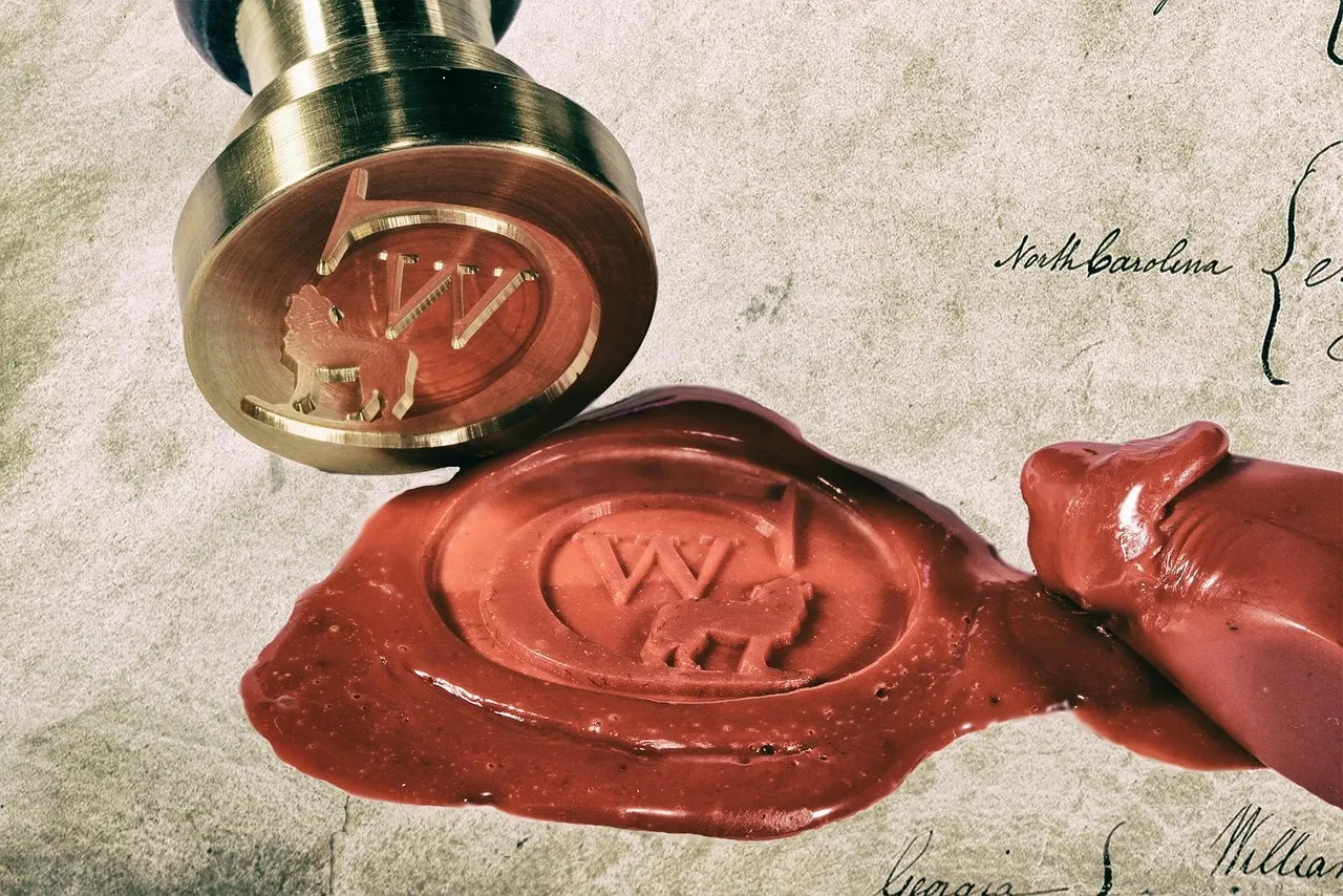 A brass seal stamp bearing a lion crest, lifted just clear of the red wax it has pressed into an old handwritten document. The wax has spread beyond the impression and the script underneath is still legible at the edges.