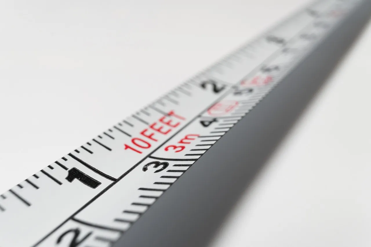 A tape rule in shallow focus, its inch and metre graduations legible